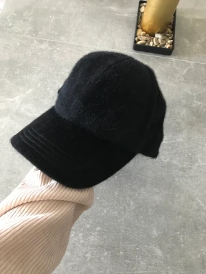 Svart keps - I gott skick. Postar antingen spårbart eller med frimärke (30 kr).