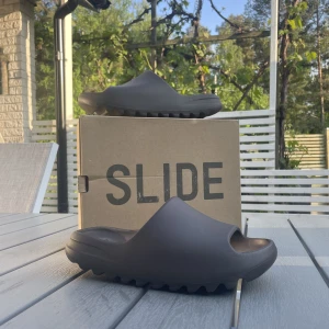 YEEZY SLIDE SOOT - Säljer dessa yeezy slides i färgen soot. I princip oanvända då de inte riktigt passar mig. Storleken är 44,5. Hör av er vid intresse! Självklart äkta! Kan tänka mig att gå ner i pris!