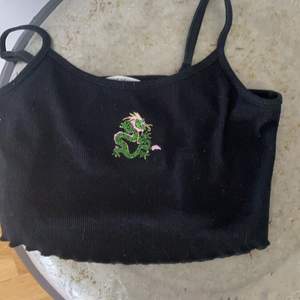  En svart kort linne med en grön drake på från Shine (Ny pris 45)