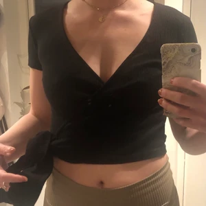 Omlott topp - Ribbad topp som går omlott framtill som man knyter i sidan. Kort i livet. Knappt använd 