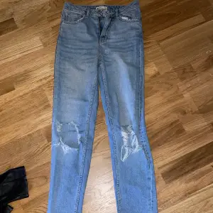 Blåa jeans med slitningar på knäna i en momjeans modell. Köpta på ginatricot, storlek 34. Kommer ej till användning längre 💖