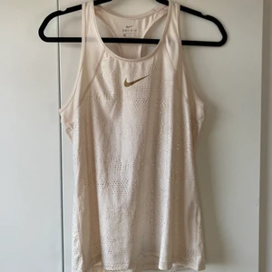 Champagnefärgat linne - Snyggt linne i champagne med gulddetaljer som kan användas dels till träning eller på fritiden