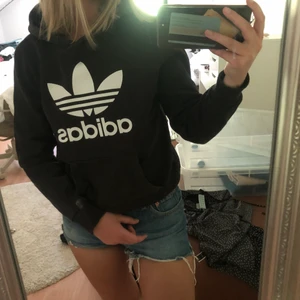 Adidas svart hoodie - Svart hoodie från adidas. Har tagit ut snörena. Bra skick bara att den är solblekt. Storlek 34. 