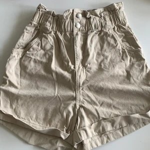 Beiga H&M högmidjade shorts  - Ett par beiga shorts som använts under en sommar. Är i super skick. Midjan är reså. 