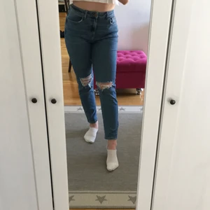 Slitna mom jeans stl 40 - Slitna mom jeans köpta i London, säljer för att de är lite för stora för mig och inte längre kommer till användning, bra skick och bekväma 