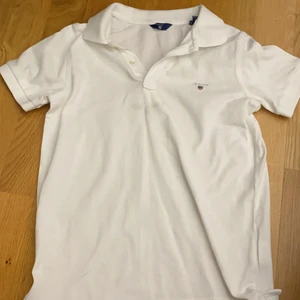 vit skjorta, storlek 9-10 år - En fin gant skjorta till din 9-10 år bror eller son. Två knappar och en krage. Lite fläckar på framsidan men det går att ta bort. Använd 1/3 gånger för länge sen.