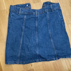 kjol i storlek 34  - En vanlig blå kjol med knappar framme som man kan knäppa upp. Använd 1 gång länge sen. Ca 2/3 år gammal. Köpt i H&M.