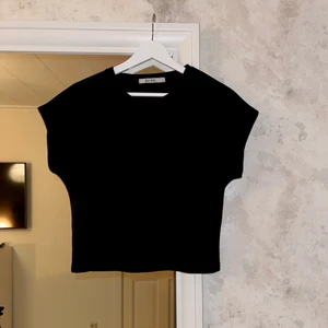 T-shirt storlek S  - Svart något kortare än en vanlig T-shirt, men inte riktigt croppad. Från nakd, storlek S 