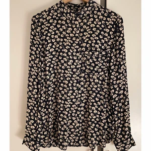 Ganni skjorta/blus - Roseburg Crepe skjorta/blus från Ganni. Lätt material i härligt djupblå färg och vitt blommönster. Säljs i perfekt skick!