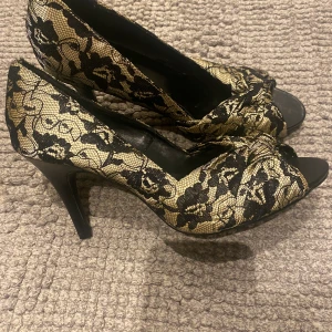 Klackskor guld/svarta - Skorna är oanvända och är i stl 39. Kan mötas upp i Nacka forum/sickla/ Värmdö eller skickas med postnord 