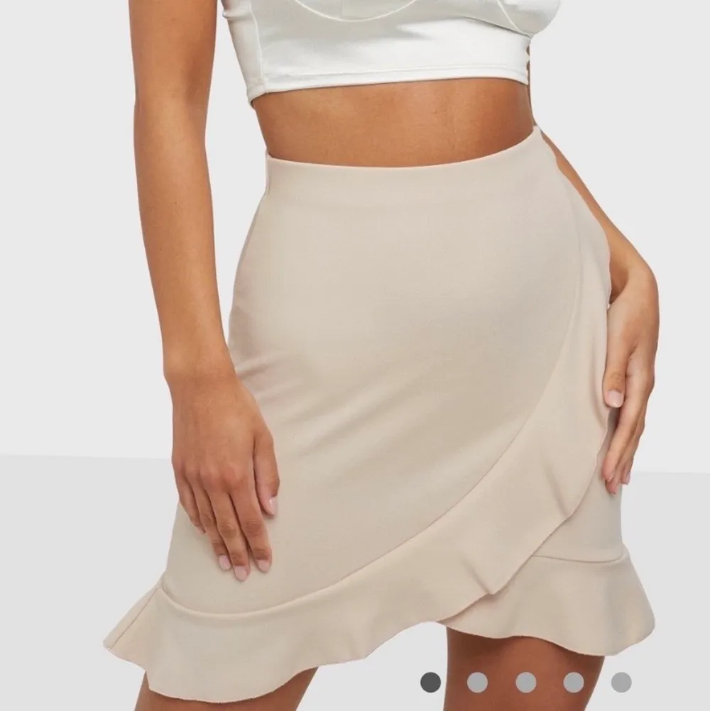 Beige fin kjol från NLY One (Nelly), den har volanger i nederkanten och har stretchigt material. Säljer den då den aldrig kommit till användning och aldrig använts dock finns prislapp ej kvar.  Nypris: 249 kr . Kjolar.