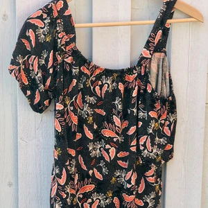 H&M blommig too - Midjekort top från H&M. Köpt för 8 år sedan. Sparsamt använd. Öppna axlar med axelband