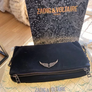 Zadig Voltaire väska - SÅLD! Lägger ut annonsen igen då köparen drog sig ur!!         Välanvänd väska från Zadig Voltaire. Mörkblå med kedjor i två olika längder. Man kan antingen ha den hängandes över axeln eller ha den snett över bröstet hängandes på höften/midjan. Väskan har få slitningar i kanter & lite på ena kedjan men inget jag tycker gör någonting. Enligt mig så är det som snyggast när den ser lite använd ut, men det är en smaksak såklart. Påse & dustbag medföljer! KOM GÄRNA MED EGNA BUD☺️
