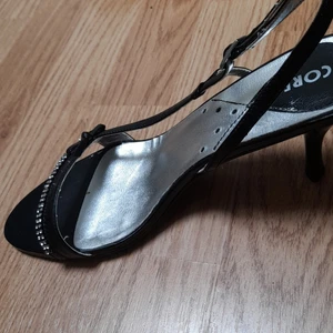 Silvriga och svarta småklackskor med pärlor. - Basic klackskor i färgen svart och silver. Med band runt till hälen. i storleken 39 från Scorett.