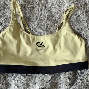 Sporttopp i märket Calvin Klein - Cool sporttopp i gul/neon                                                          Går ej att stoppa in pads                                                         Säljes pga att den inte passar längre