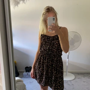 Blommig klänning  - En blommig svart fin klänning från bikbok i storlek XS. Väldigt fin till sommaren.