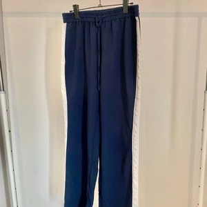 Byxor Monki - Vida byxor med vit rand på sidorna från Monki. Storlek 40.