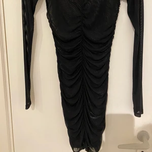 Svart genomskinlig klänning - Svart genomskinlig klänning med detaljer. Man har den över en lättare klänning, men har tyvärr inte den klänningen. Strl XS men passar även S