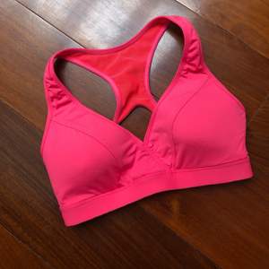 Pink sports bra with high support. Very tight fit.
