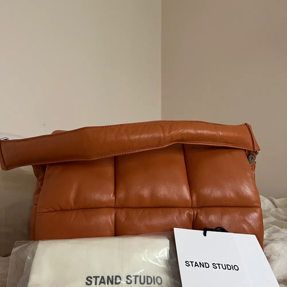 Säljer världens finaste väska från stand studio i färgen mandarine (säljs inte längre). Den är sparsamt använd (5ggr) och i äkta läder. Dustbag, 2 band och stand studio lappen tillkommer. OBS! Det ena lite längre bandet är förkortat hos skinnskräddare så den går att antingen ha hängandes under armen eller som crossbody (hamnar precis vid höften). Nypris 3900kr. Kan tänka mig att sälja för bra pris, köparen står för frakt! . Väskor.