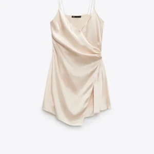 Satin klänning - Ljusrosa/ champagne färgad kort klänning från Zara. Den är helt slutsåld på hemsidan. Endast använd vid ett tillfälle.