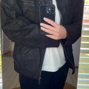 Retro skinnjacka-mockajacka Clifton - Vet ej storlek men jag är vanligtvis 38/M och den är oversize på mig. Utvändigt som ny. Tyget invändigt finns tecken på användning men knappt märkbart. En jacka från min ungdom som då köptes ny på JC och använd då cirka 1 år. Äkta skinn/mocka. 