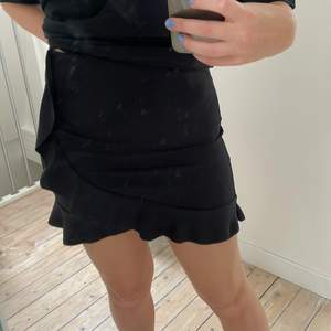 En svart kjol med volanger från NLY ONE. Storlek M men är ganska kort. Köparen står för frakten💓