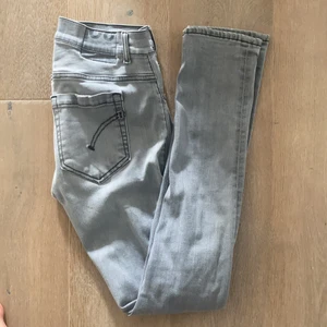 Dondup jeans - Gråa Dondup jeans i modellen George skinny fit. Värt att notera (!) ett litet hål mellan benen, därav nedsatt pris. Ursprungspris: 3000kr
