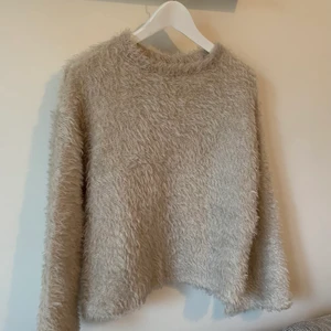 Lurvig tröja från Zara - Lurvig stickad tröja från Zara i fint skick. Färgen är ljus gråbeige. Passar XS-M beroende på hur man vill att den ska sitta på
