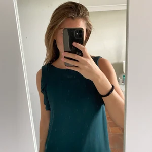 Grön blus - Grön kortärmad blus från H&M! Den har fina detaljer vid ärmarna. Baktill finns en knapp som man knäpper. Den är i storlek 34 men passar även 36, vilket jag är. Köparen står för frakten🥰