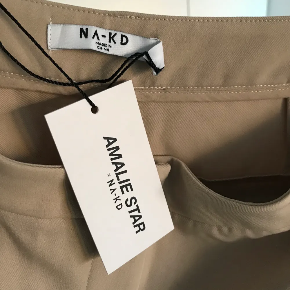 Sjukt fina kostymbyxor i beige från Amalie Stars kollektion med NAKD. Säljs inte längre och kommer inte komma in i lager igen, ett väldigt sällsynt plagg så passa på! Helt nya och aldrig använda. Säljer pga för stor storlek! GRATIS FRAKT.. Jeans & Byxor.