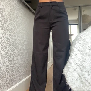 Kostymbyxor - Säljer dessa svarta kostymbyxor från NA-KD i storlek 34. Dom är lagom långa på mig som är 168-169 och dom är använda endast ett fåtal ggr🤍