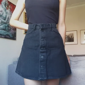 Svart Jeansskjol - Söt svart jeanskjol från Monki. Den har knappar hela vägen ner på framsidan och fickor på baksidan   Skriv om du har frågor eller vill veta exakta mått :-)