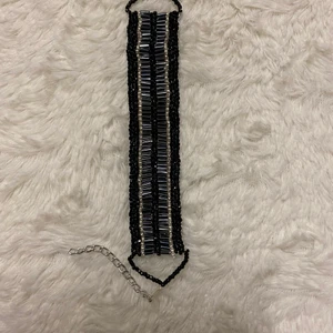 Handgjord armband - Denna fina armband har jag gjort själv. Den är gjord på glaspärlor. Den är ca 10-13 cm lång utan kedjan och låset medräknat. 