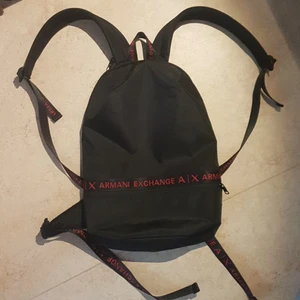 Armani rgyggsäck Köpt på Zalando - Den är ny helt oanvänd från zalando. Köpte den för att det var REA så jag köpte bara den för att det var en armani väska. Nypris 1145kr https://www.zalando.se/armani-exchange-backpack-unisex-ryggsaeck-blackred-arc54o00a-q11.html Tar Swish och kontant.               