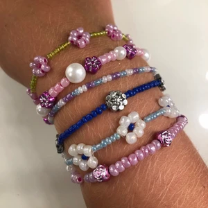 Pärlade armband - Säljer massa fina armband som jag har pärlat själv💜Kolla gärna in mina andra annonser för andra egengjorda smycken☺️ Kom gärna med egna förslag på design å färg!!🥰 Pris för ett armband med bara små pärlor: 25kr, ett med blandat små och stora pärlor: 30kr, ett med blommor: 40kr⚡️⚡️ Frakt tillkommer på 13kr:) 