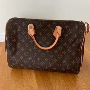 Äkta Louis Vuitton väska Speedy 30 - handväska från Louis Vuitton inköpt i USA  Den är i ett fin skick med tillhörande nyckel och lås. Mönstret är klassiskt monogram och är i ett stycke samt två sidostycken. Handtagen är i läder och åldras fortfarande, mörknar i takt med att väskan används. För fler bilder, skicka ett pm. Nypris: $ 1, 160.00  Details: 30 x 21 x 17 cm  (Length x height x width ) Monogram coated canvas Natural cowhide-leather trim Textile lining Gold-color hardware Padlock Inside zipped pocket D-ring Handle: Double 