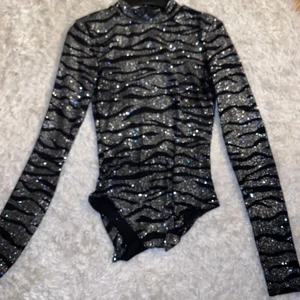Glitter party topp - En jätte fin body som är öppen i ryggen. Den är bekväm inuti och sticks inte. Säljs då jag inte använder den så mycket. Jag har tagit bort knapparna så den går inte att stänga men är lika fin nerstoppad i byxorna!! 
