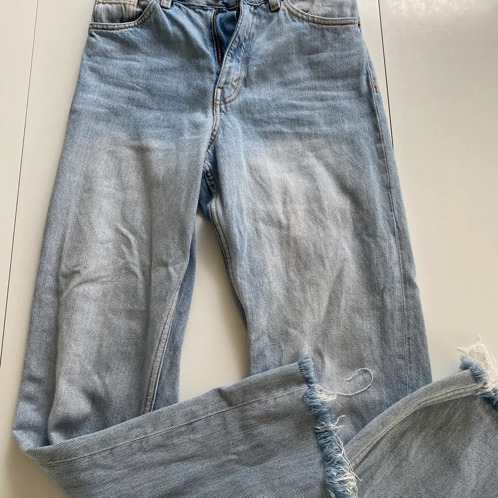 Ljusa MONKI jeans, hög midja, vida ben som är klippta/fransiga nedtill. 90-tals modell. Ganska små i storlek så passar 24-25. Snyggt slitna och sköna i tyget.. Jeans & Byxor.