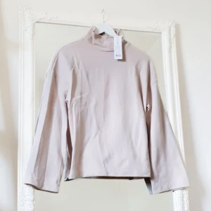 beige tröja XS Gina Tricot NY!! - Färg: beige.  Strl: XS.   Fin tätstickad tröja från Gina Tricot.  OBS. HELT NY!! Med trumpetärm. Midjelång. Polokrage.  Material: 58% Polyester, 42% Bomull. Betalning via swish, frakt tillkommer.