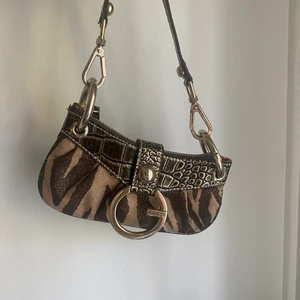 Väska - Säljer en så fin liten väska från gues❤️ lite äldre❤️  i nyskick! Skriv för fler bilder💓 Buda!!                           budat är budat❤️Frakt=48kr