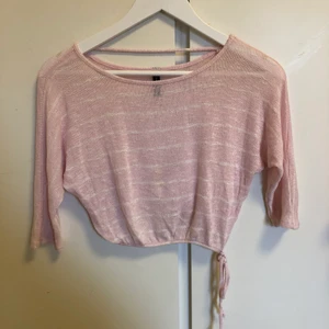 Stickad kort topp - Liten storlek; XXS/XS. Knappt använd. Kort med snöre i midjan samt ärmar som går till armbågen.