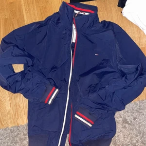 Tommy Hilfiger jacka - Blå Tommy Hilfiger Bomberjacka.                                         Fint skick, nypris 1200kr säljer för 300kr.              Köparen står för frakt, annars kan jag mötas upp i Stockholm.