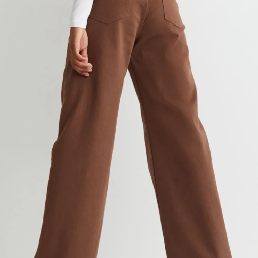 Är ett par bruna långa 5-ficksbyxor i strechig bomullstyg, byxorna är högmidjade och vida, raka ben , har också gylf med en dragkedja och knapp . Jeans & Byxor.