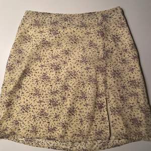 Gul kjol med blommor i olika färger och en slits från. Från nakd i storlek 36