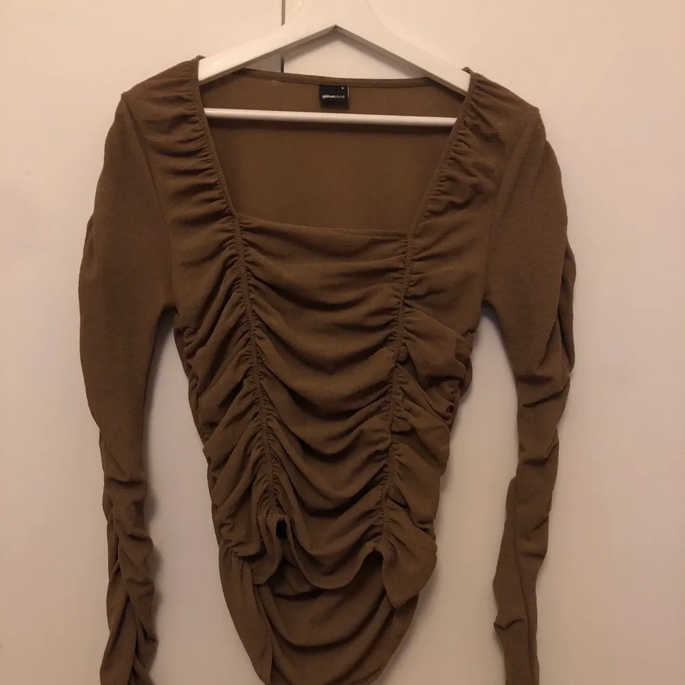 En brun spacy tröja från Gina. Första bilden är lånad. Aldrig använd. Köparen står för frakten . Toppar.