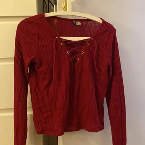 Tröja - En snygg röd tunn tröja från hm. Snörning i fram som går att justera. 