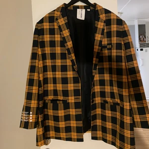 Rutig kavaj - En rutig kavaj med mörkblåa och senapsgula rutor i storlek 54. 