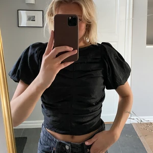 Svart topp - Svart festlig topp med puffiga ärmar. Från Gina tricot. Helt oanvänd med prislappen kvar! Inköpt för 399 kr