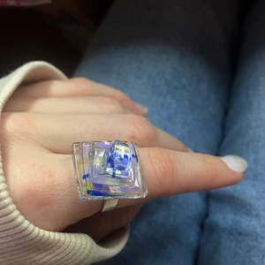Ring - Säljer min fina, unika ring då den tyvärr inte kommit till användning. Ringen ser ut som ett glasliknande material med inslag av olika färger (blå, gul, orange). Skulle vilja säg att den passar S/M. Meddela mig vid fler frågor!😊
